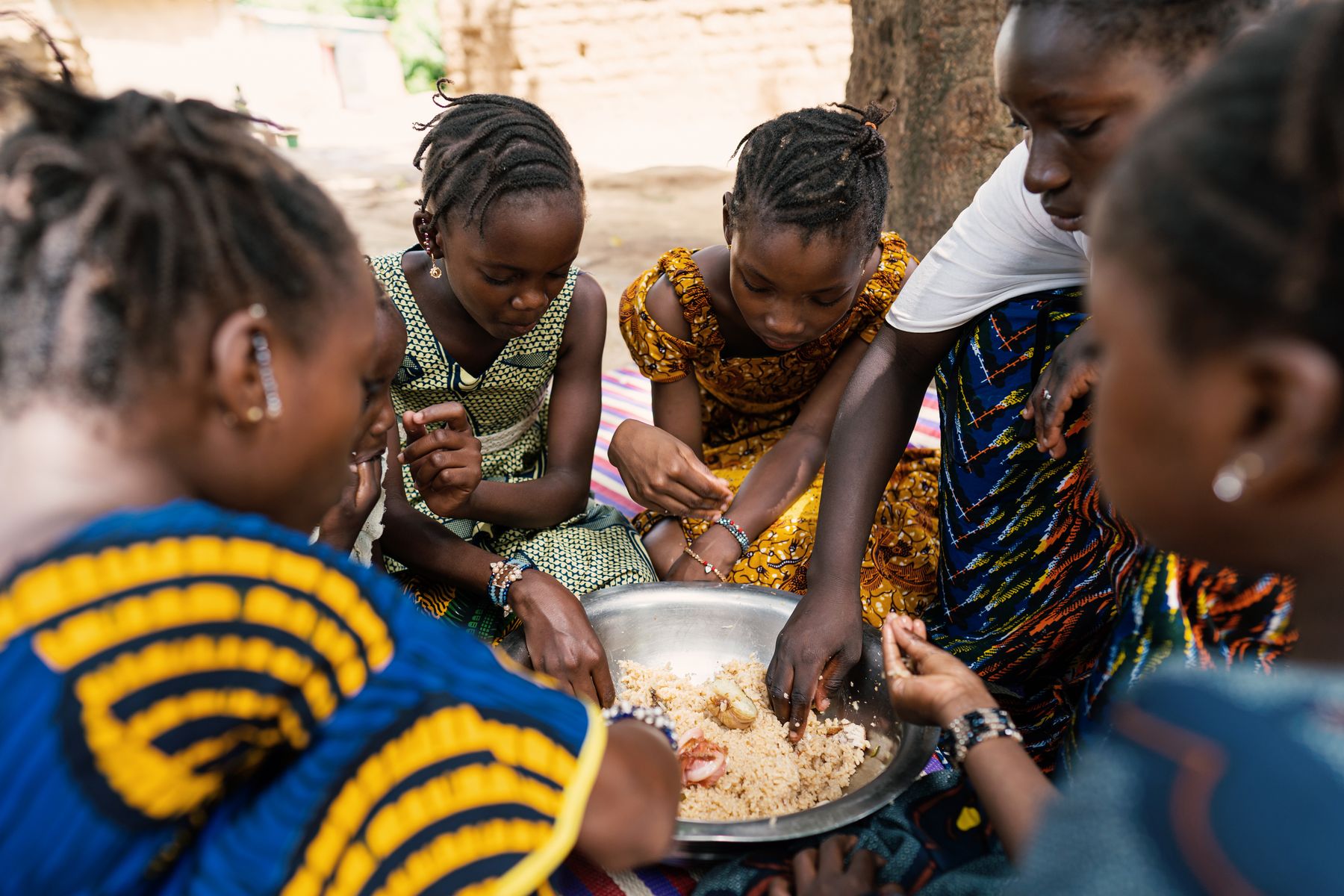 Girls sharing a meal from a large bowl